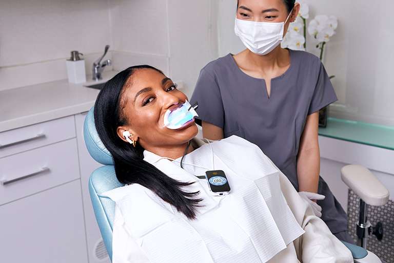 Image of a patient with the GLO whitening device in their mouth.
